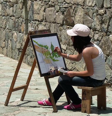 Chica pintando un cuadro al aire libre